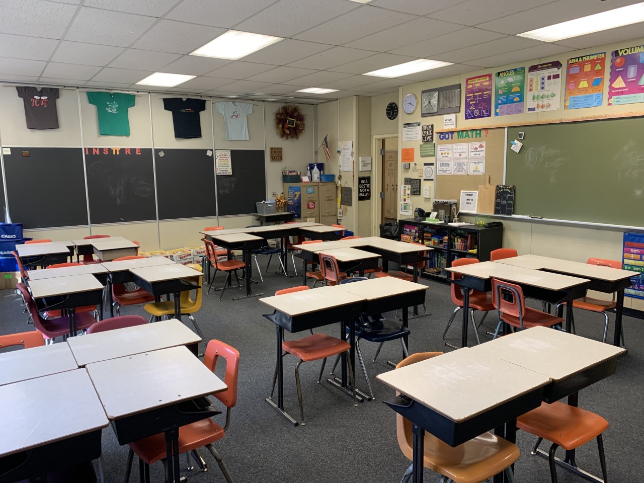 Dense classroom layout with desks and chairs formed in small clusters.